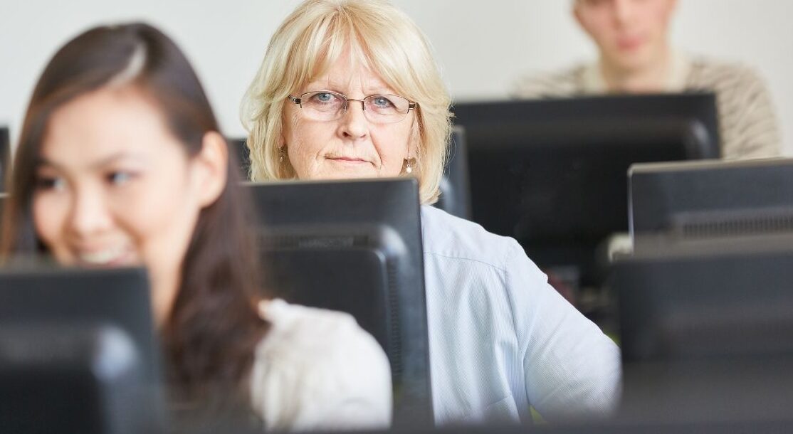 an elder student behind a computer
